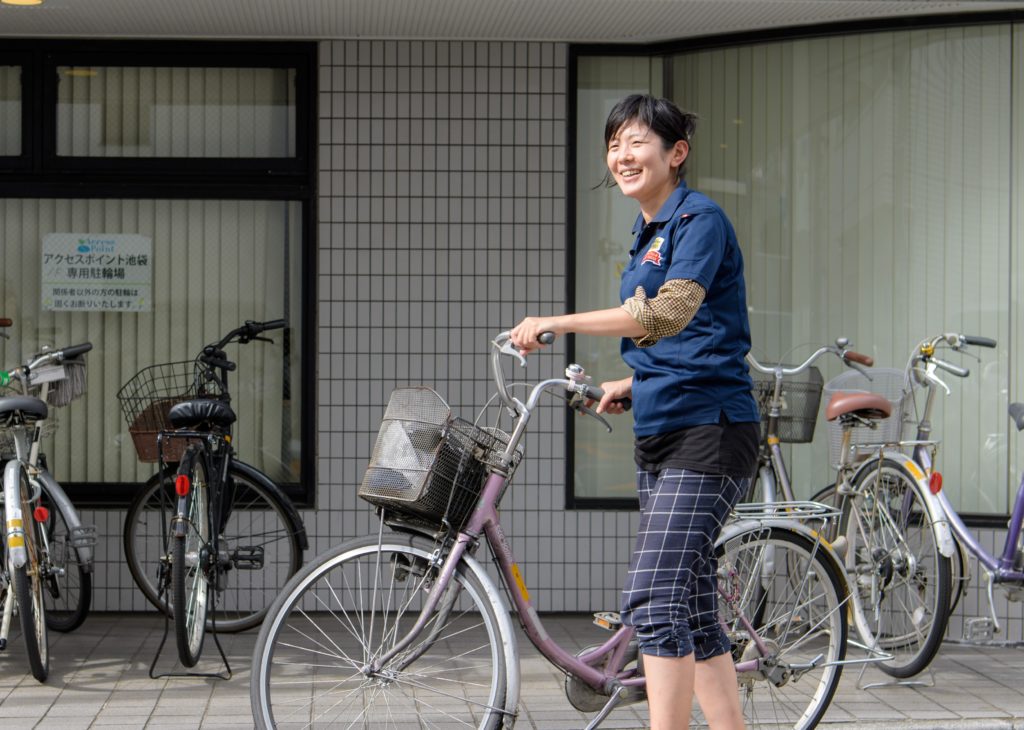 自転車を押すスタッフ